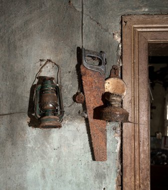 Eski fenerler ve duvarda asılı testere 