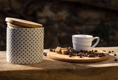 Kahve fincanı, fasulye ve şeker kasesi açık havada.