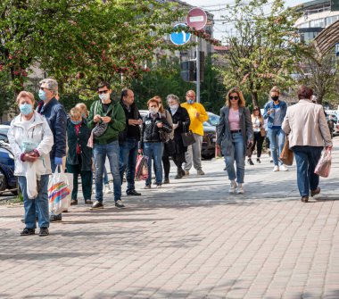 UZHOROD, UKRAINE - 29 Nisan 2020: Uzhhorod şehrinde bir salgın sırasında pazara kuyruk. Coronavirus salgını sırasında güvenli bir mesafede beklemek.