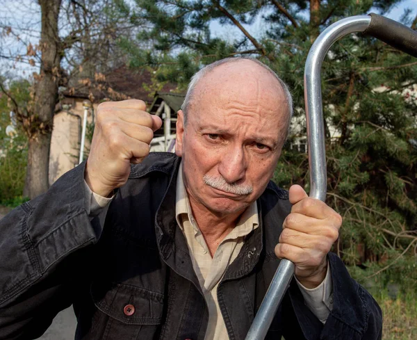 老人は屋外で杖で脅かす — ストック写真