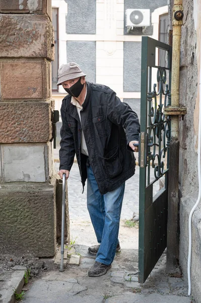 Senior Man Skyddsmask Med Käpp Poserar Nära Porten Utomhus — Stockfoto