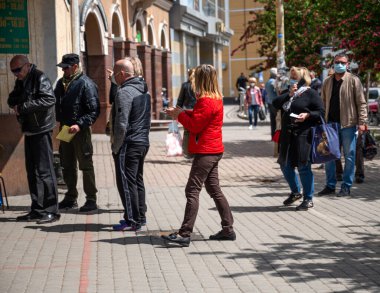 UZHOROD, UKRAINE - Mayıs 07, 2020: Uzhhorod şehrinde bir salgın sırasında pazara kuyruk. Coronavirus salgını sırasında güvenli bir mesafede beklemek.