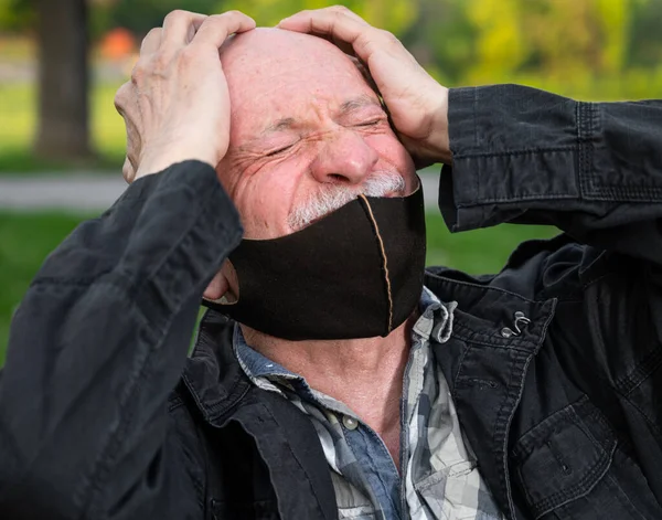 Yüzünde Maske Olan Kıdemli Bir Adam Baş Ağrısı Çekiyor — Stok fotoğraf