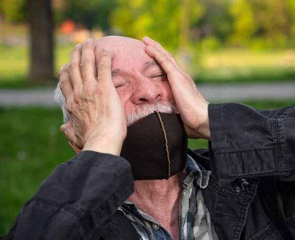 Hombre Mayor Máscara Facial Que Sufre Dolor Cabeza Aire Libre —  Fotos de Stock