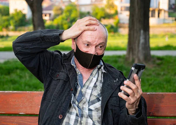 Šťastný Senior Muž Masce Obličeje Pomocí Smartphone Venku — Stock fotografie