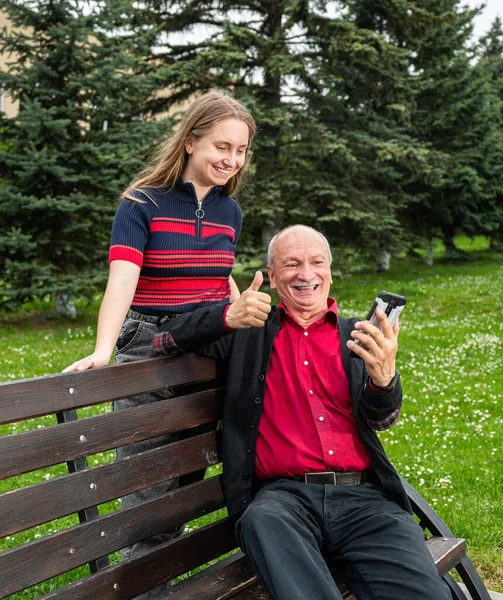 Portrait Happy Granddaughter Grandfather Sitting Bench Using Cellphone — Stock Photo, Image