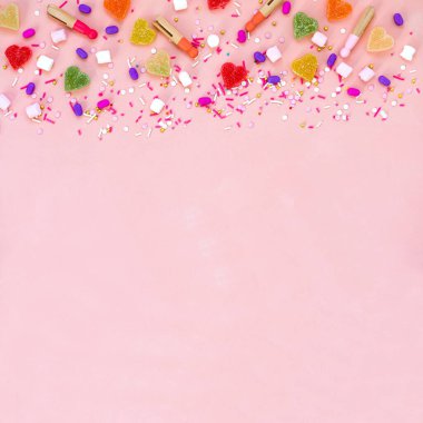 Üst düzey dekorasyon çeşitli şekerleme ve jöleli şekerler iyi tatiller konsepti. Güzel pembe masanın üzerinde düz renkli şekerler yatıyordu. Boşluğu kopyala.