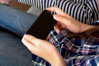 Çevrimiçi eğitim ve çalışma mesafesi. Kırpılmış kadın elleri cep telefonu.