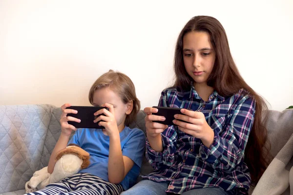 Formazione a distanza online istruzione e lavoro. I bambini imparano a distanza da casa. Uso del telefono cellulare — Foto Stock