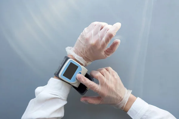 戴医用手套的女性手使用血压监测器。卫生保健医生的概念。打起精神 — 图库照片