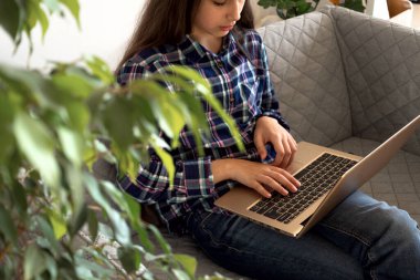 Çevrimiçi eğitim ve çalışma mesafesi. Kırbaçlanmış kadın ofis işi evden kanepeye kadar uzanıyor. Laptop kullanılıyor