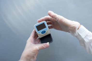 Eldivenli kadınların ellerinde tansiyon monitörü var. Sağlık sigortası doktor konsepti. Model.