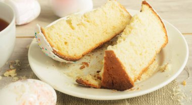 Paskalya bayramı. Paskalya kahvaltısı. Tabakta tatlı Paskalya pastası ve hafif ahşap arka planda Paskalya yumurtaları..