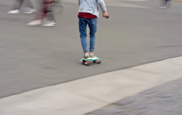 Девушка едет на скейтборде по улице . — стоковое фото