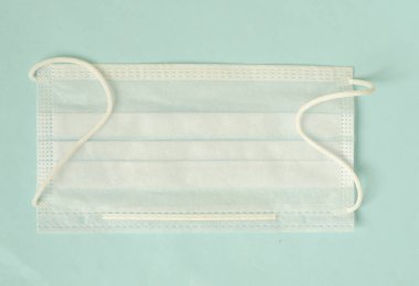 Virus pandemic protection concept. One medical mask on light blue background.