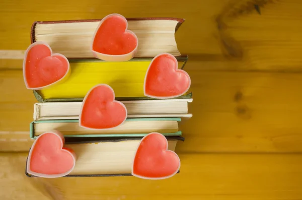 Love hearts on books on wooden background.Book lovers.