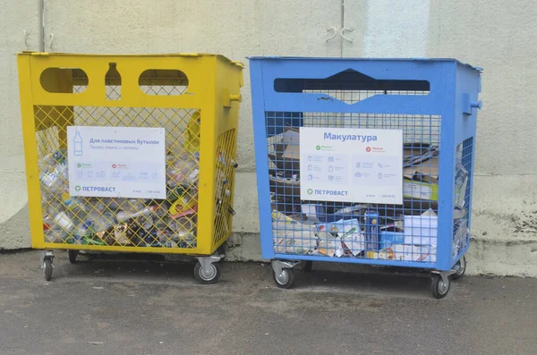St. Petersburg, Russland - 16. März 2020: Getrennte Müllabfuhr. Ein Container zum Sammeln von Plastik, der andere für Altpapier. lizenzfreie Stockbilder