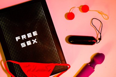Kırmızı gstring ve seks oyuncakları pembe arka planda bir posta kutusuyla 