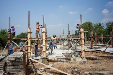 Ratchaburi, Tayland: 1 Mart 2018 - Bir grup işçi inşaat alanındaki ahşap modele karışık çimento dökerek evin temelini attılar