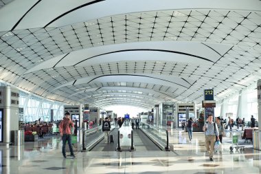 Hong Kong Uluslararası Havalimanı, Hong Kong: 21 Kasım 2019 - Havaalanı terminalinin içinde, koridorda otomatik yürüyen merdivenle bekleyen yolcularla birlikte perspektif