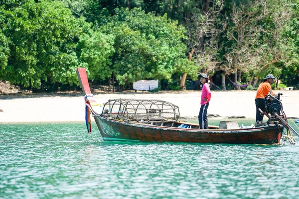 Ko Lanta 、クラビ、タイ: 10月22 、 2019 -漁師は伝統的なロングテールボートを運転し、バックグラウンドで無人島と晴れた日にツールで魚を見つける — ストック写真