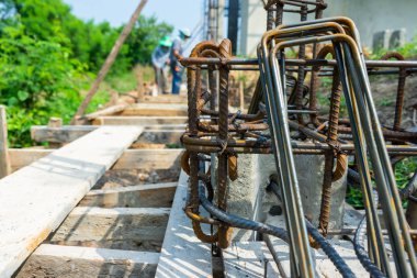İnşaat alanındaki bulanık işçilerle beton yapı için güçlendirilmiş çelik üzerine seçici bir odak