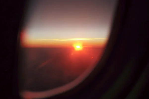 蓝天背景的天际线上的夕阳和前景中飞机窗台的阴影 — 图库照片
