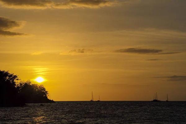 Silueta de barcos de la isla y del yate en la línea horizontal con la luz del atardecer y del cielo crepuscular en el fondo — Foto de Stock
