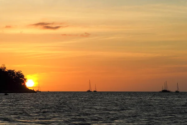 Silueta de barcos de la isla y del yate en la línea horizontal con la luz del atardecer y del cielo crepuscular en el fondo — Foto de Stock