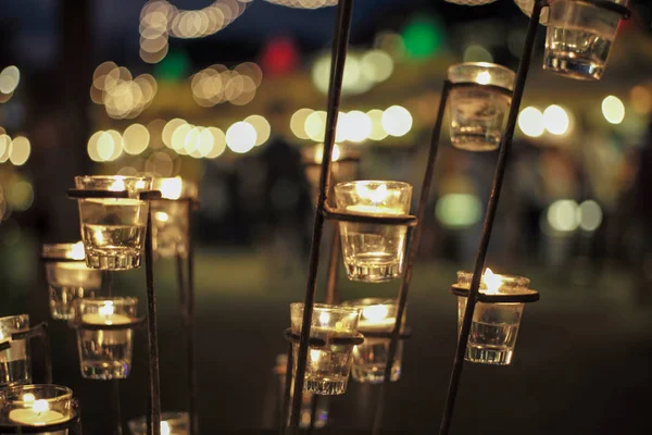Selektiver Fokus auf Kerzen in kleinen Gläsern mit verschwommenem Bokeh-Licht im Hintergrund — Stockfoto