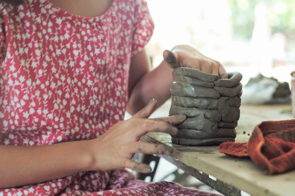 Closeup clay pottery under production with blurred motion hands of little girl in workshop — Stock Photo, Image