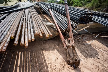 Kapalı paslı kesme aracı inşaat alanındaki takviye çelik yığınına yaslanıyor