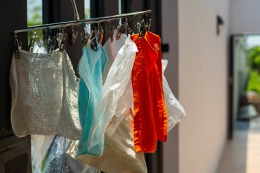 Pek çok paçavra parçası güneş ışığıyla kurumak için mandalla asılıyor.