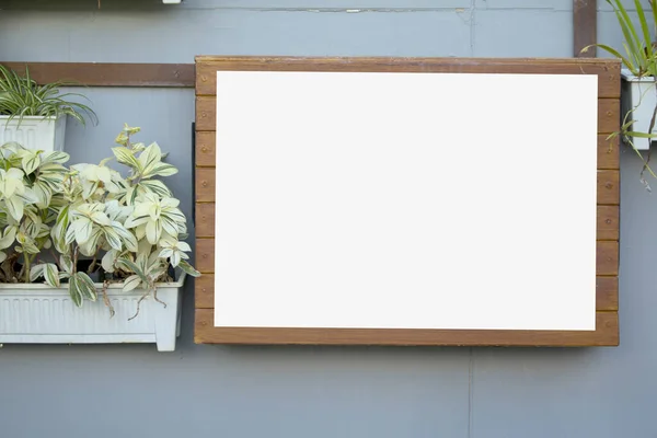 Holztafel mit weißem Papier an grauer Wand — Stockfoto