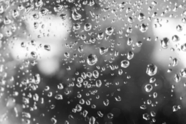 Agua borrosa cae sobre el fondo de cristal de la ventana. —  Fotos de Stock