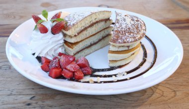 Vanilyalı dondurma, krep ve ahşap çilekli.