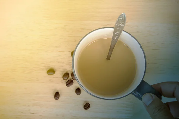 Una taza de café con leche y granos de café en la mesa — Foto de Stock