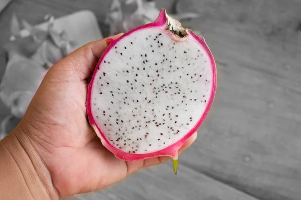 Håndholdt Dragefrukt på trebakgrunn, skåret delikatesse – stockfoto