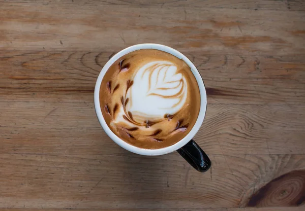 Tutup cangkir kopi seni latte panas di atas meja kayu. — Stok Foto