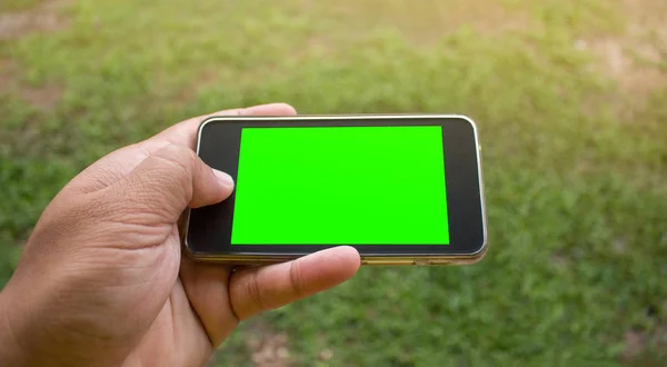 Enfoque suave de la mano usando el teléfono inteligente móvil con backgro borroso — Foto de Stock