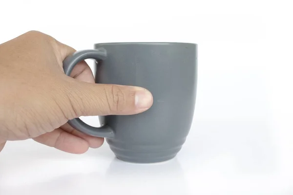 Mão segurando caneca de café cinza no fundo branco — Fotografia de Stock