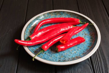 Koyu renkli ahşap plaka içinde kırmızı biber