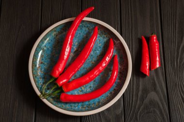 Koyu renkli ahşap plaka içinde kırmızı biber
