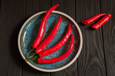 Koyu renkli ahşap plaka içinde kırmızı biber