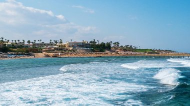Plajda şemsiye ve deniz dalgaları ile görünümünü. Kızıldeniz, Sinai, Mısır. 