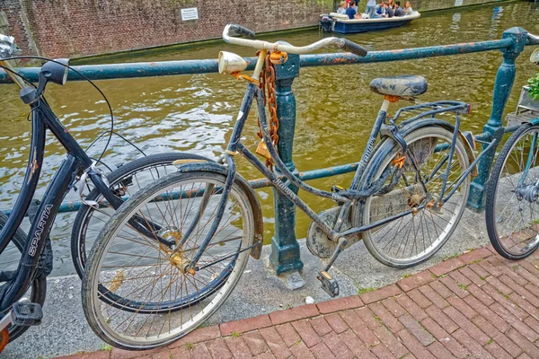 Bicicletas de Ámsterdam aparcadas junto al antiguo canal fluvial —  Fotos de Stock