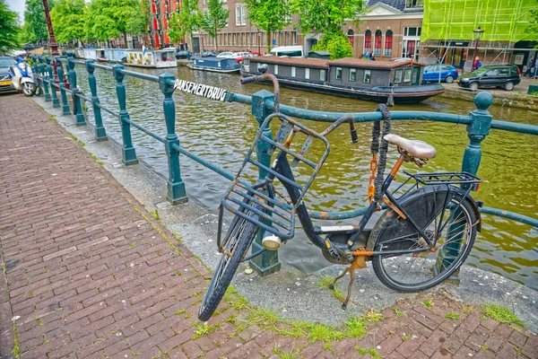Amsterdam bicycle parked by old river canal — Stock Photo, Image