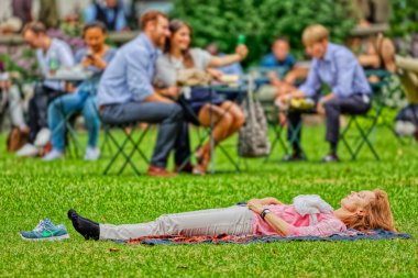 Kadın Bryant Park, New York 'ta dinleniyor.
