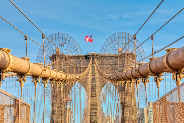 The United States flag on center of Brooklyn Bridge construction in New York