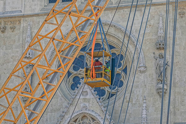 Zagreb, Croatia - April 16, 2020 : Cathedral belfries were damaged in an earthquake. Engineers and alpinist use the lift to reach the north tower and prepare it for controlled demolition